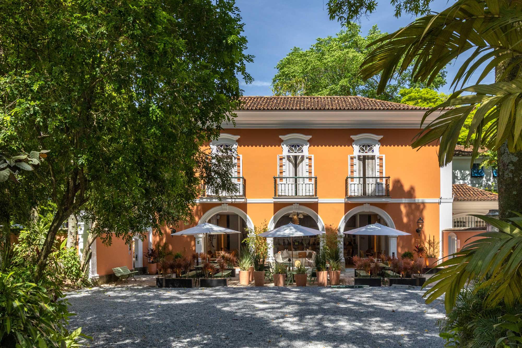 Maurício Nóbrega Arquitetura – Casa Bistrô. No espaço antes reservado à garagem da residência, numa área recuada de seu amplo jardim, o restaurante traz um mix de peças de estilos diversos – muitas delas encontradas na própria casa e sem uso há anos. O uso de plantas como divisórias e a manutenção de revestimentos como os antigos azulejos do espaço trazem mais personalidade ao ambiente. O mobiliário privilegia mesas grandes e espaçosas que possibilitam o distanciamento até mesmo entre pessoas de um mesmo grupo.	 