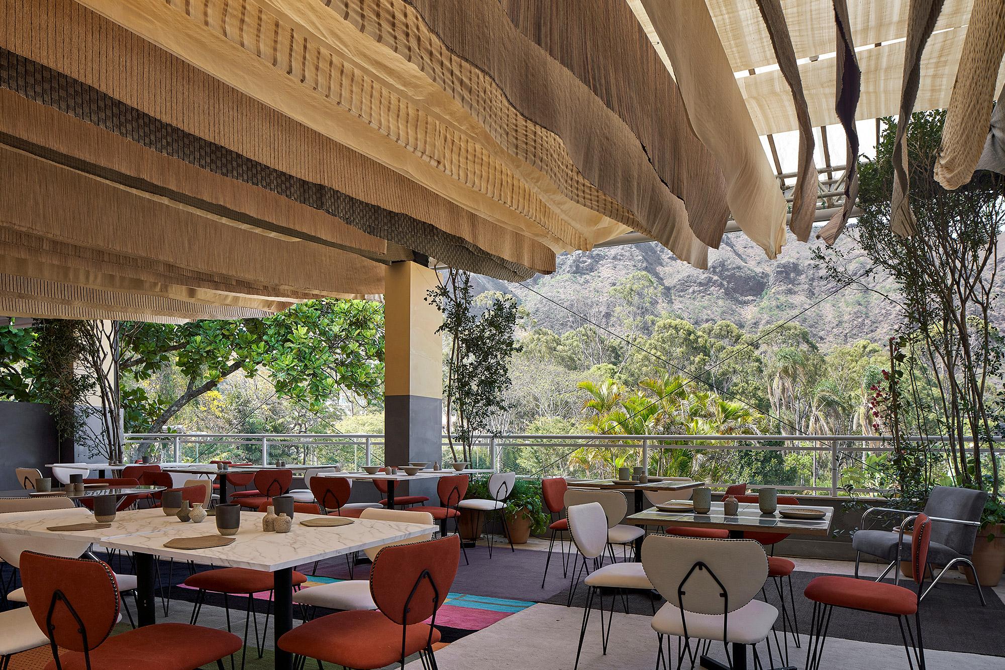 Antônio Valladares, Joana Hardy e Tereza do Prado - Casa Tereze - Restaurante Outland “Al Mare”. O restaurante alegre, muito charmoso e colorido, foi pensado como um espaço de celebração e encontros. Os profissionais criaram as cerâmicas, executadas pelo Ateliê da Vila, tanto as utilitárias, como as luminárias. No teto, cabos de aço esticados recebem sedas em várias padronagens, como se fossem flâmulas. Também multicoloridos, retalhos de tapetes cobrem o piso. Peças de família e de antiquários compõem o décor.