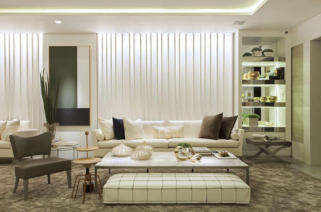 Living do Apartamento Master - Sérgio Palmeira. As riquezas das jazidas naturais brasileiras inspiraram o profissional, que destaca o branco dos sofás em linho e demais móveis, formando uma composição elegante com o couro fendi. Nos detalhes, dourado, cobre e prata não poderiam faltar. As telas são de autoria de Nardelli.