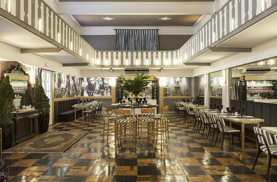 Restaurante Piano Bar - Rita Garajau. A tradição e o glamour do Praia Tênis Clube, com uma história de 80 anos, são revividos sob um olhar atual. A estrutura interior foi mantida, mas o mobiliário investe em linhas retas e sem excessos. O layout otimiza as circulações e revela a opção pelos bancos utilizados como assentos das mesas nas laterais, liberando o espaço que totaliza 90 m².