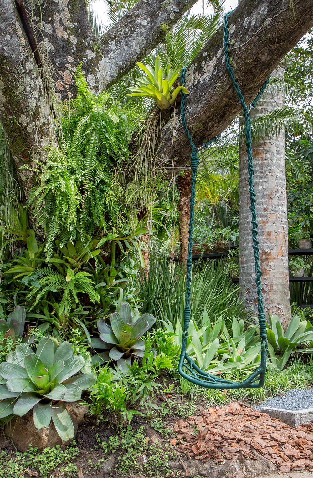 <span>Jardim Recanto do Lago - Anna Luiza Rothier. Quando conheceu os jardins tropicais de Burle Marx, Anna Luiza Rothier se encantou com as formas irregulares dos canteiros, com espécies que conhecia desde criança. Aqui, ela se sentiu em casa e inseriu uma grande mesa que apoia a churrasqueira, entre outros móveis da Tidelli, como as poltronas Veleiro em alumínio e corda verde musgo, de Luciano Madelli.</span>