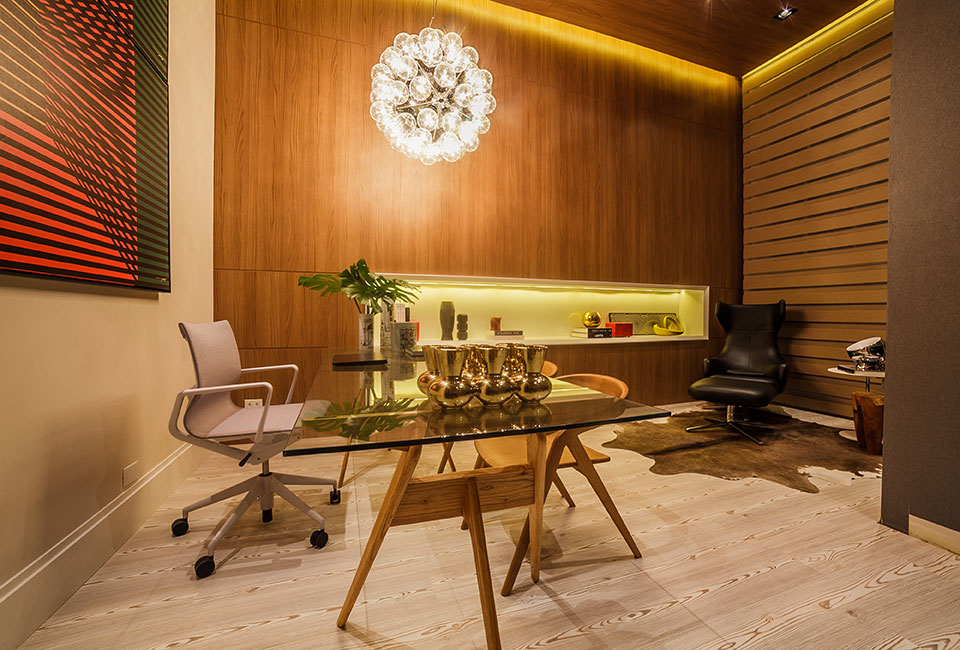 Home Office - Carla Grüdtner. No espaço de 21 m², a madeira é destaque. O piso laminado em pinus e o revestimento de melanina no teto e nas paredes criam uma caixa aconchegante, recortada por um nicho embutido com pintura laca. Na iluminação, a escolha foi o LED, mais ecológico.