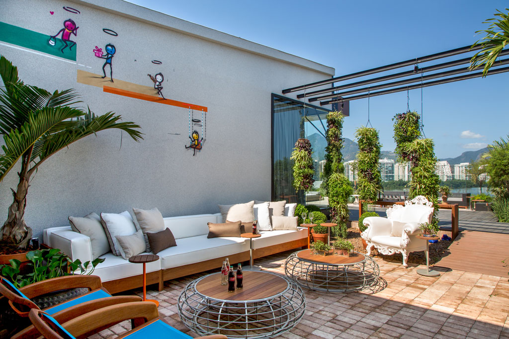 Balcony Inspiration - Os paisagistas Guilherme Portugal e Karyne Lima apresentam o jardim vertical composto de cilindros verticais que descem do teto repletos de vegetação. O piso em madeira ecológica, com um intertravado Handscape da Ekko, vem acompanhado do tapete Nature para área externa da Casa Julio. As paredes são forradas com papel de seda imitando aguadas de tinta, variando do bege ao preto (da By Floor). O sofá e o aparador Vida Boa (MAC) deixam o espaço ainda mais receptivo.