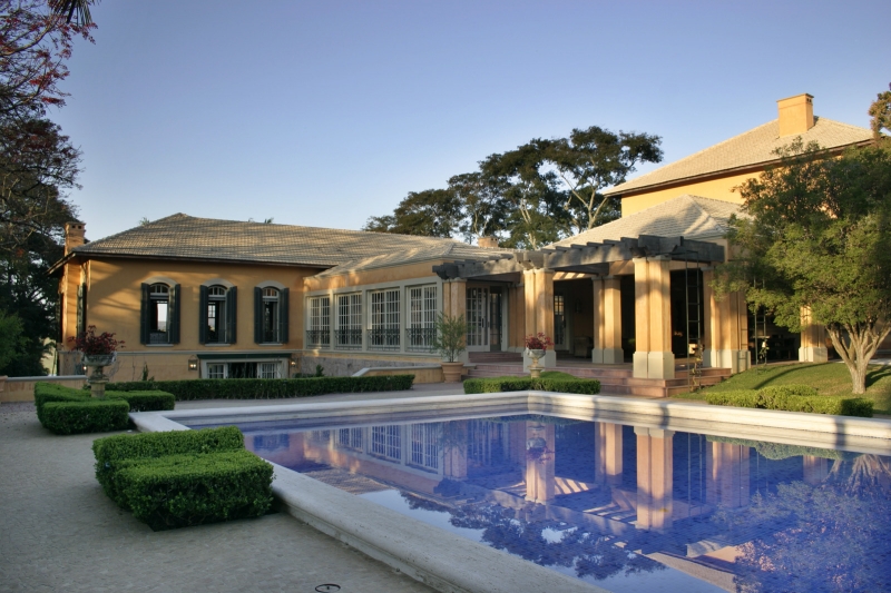 A piscina é um dos destaques do projeto e ladeia quase toda a residência.