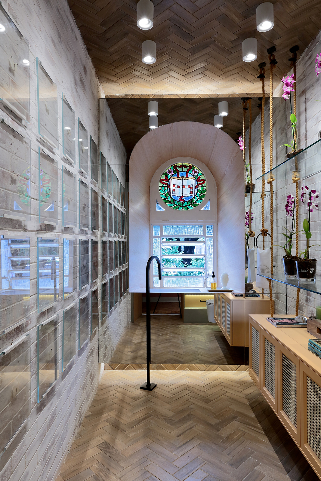 Lavabo do Andar - Ana Maria Freire e Camilla Pereira. O ambiente faz uso do vitral do casarão para criar um espaço feminino e elegante. Paredes semi-descascadas e cordas ficam juntas das pinturas em laca, espelhos, prateleiras em vidro e quadros translúcidos presentes no ambiente.