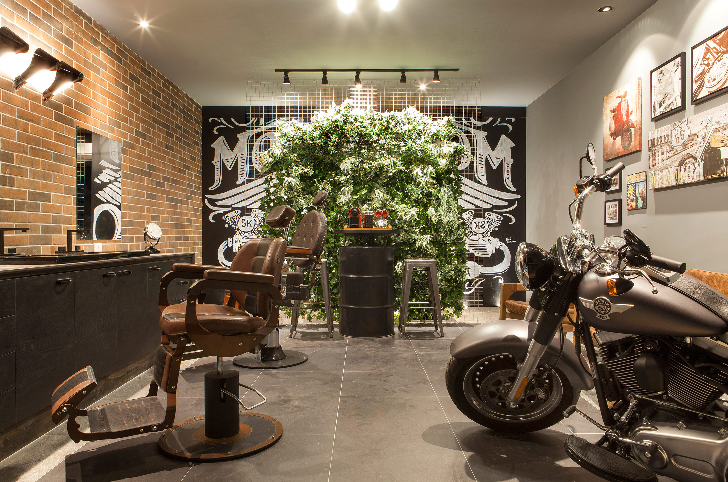 Lavabo Masculino do Deck - Patrícia Davel. Além de ser um lavabo, o local possui barbearia e expõe uma moto que torna-se tema do ambiente: "Harley". Tons neutros e sóbrios, como o preto e o cinza, tijolo aparente e obras retrôs complementam a atmosfera masculina do espaço.