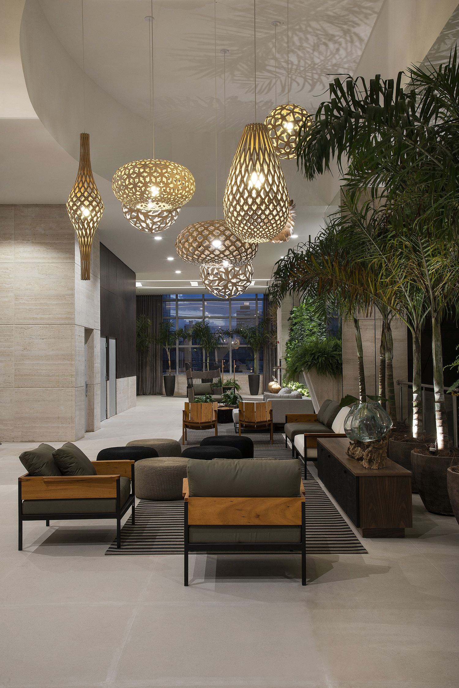 Praça – Jefferson Castro. Os 385 m² foram divididos em três ambientes de convivência. Além de um espaço flexível para eventos e um lounge, o projeto oferece este living com assentos em várias configurações, para pequenos ou grandes grupos. O mobiliário apresenta referências do design, como Paulo Alves e Rejane Carvalho. Na iluminação, uma chuva de pendentes de David Trubridge.