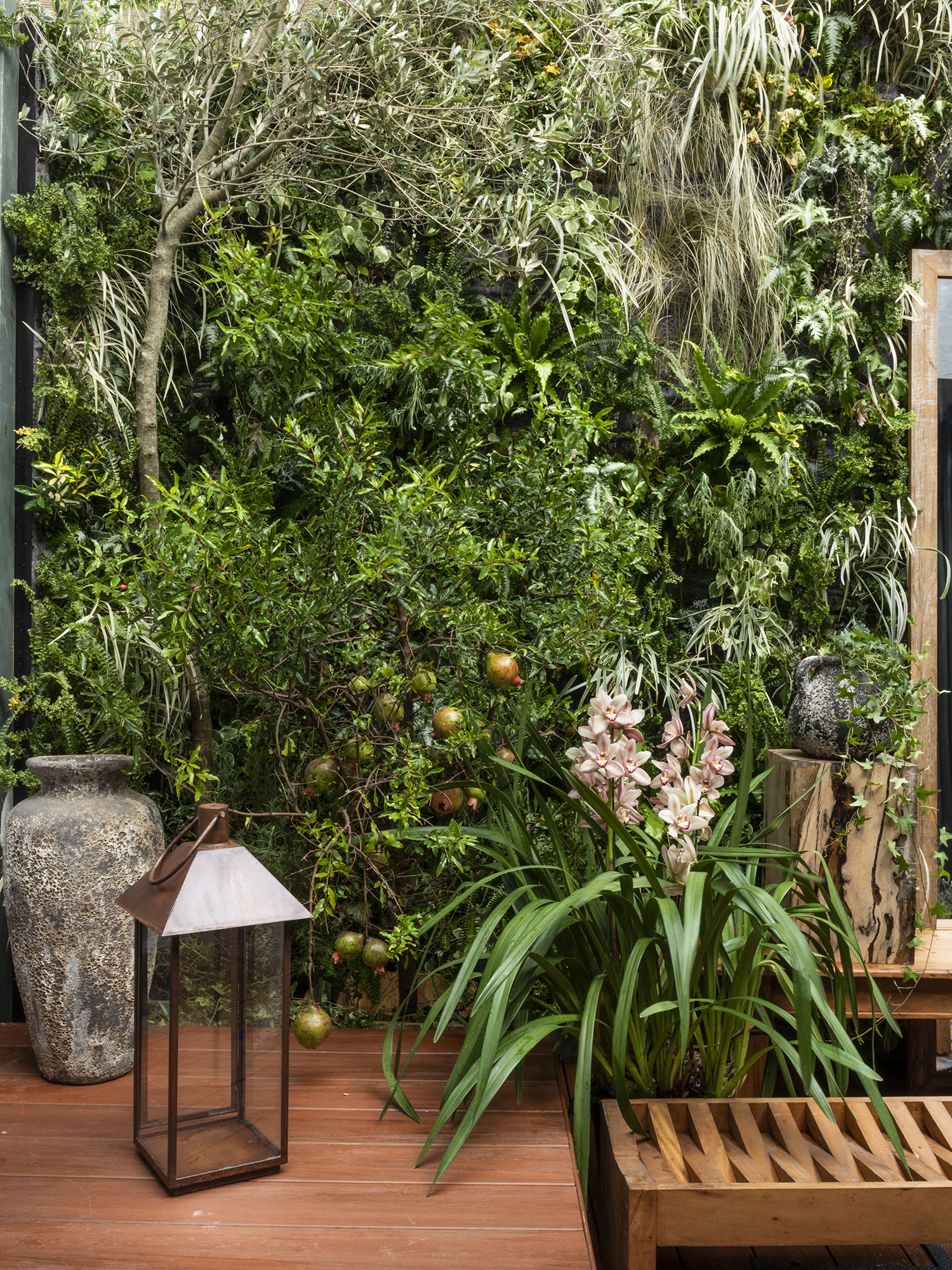 CASACOR São Paulo 2018. <span>Jardim do Entardecer - Myrian Marquez. Oliveiras e romãzeiras em vasos, entre outras plantas, criam uma atmosfera onírica que celebra o feminino. Mais precisamente, as ninfas gregas Hespérides, que personificam o entardecer. O banco de madeira ecológica convida a apreciar a paisagem.</span>