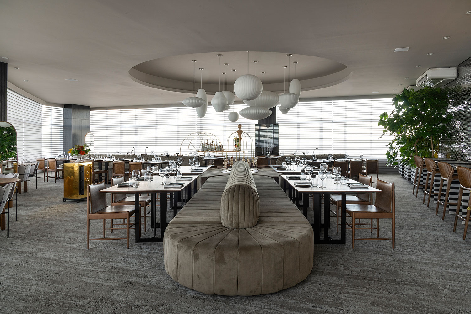 CASACOR Goiás 2018: <span>Restaurant – Leo Romano. Com a vista do 50º andar do edifício, o projeto traz a atmosfera dos mais famosos restaurantes “top floors”, com uma pegada cosmopolita. O layout se desenvolve ao redor do grande sofá em formato de "Y", assinado pelo próprio Leo Romano. Ele define as posições das mesas, com cadeiras Cantu, de Sergio Rodrigues. Leo desenvolveu a identidade visual das louças, e todos os objetos são assinados por ele em parceria com a artista e designer Ieda Jardim. E, claro, há a sequência de 12 pendentes Bubble Saucer, de George Nelson, para arrematar.</span>