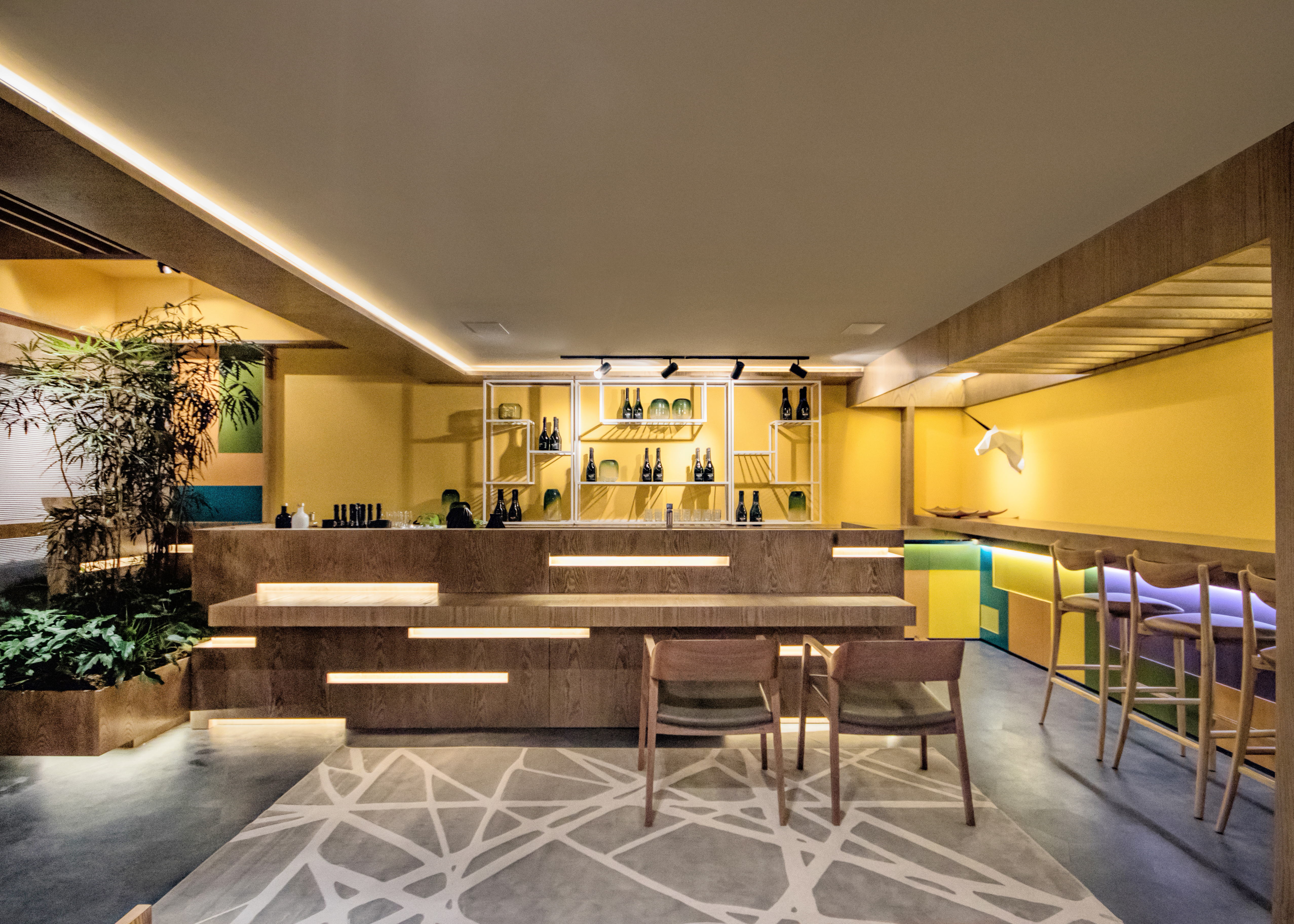 Upscale Bar - Alessandro Cavalcanti e Ricardo Makhoul. Este bar solar tem inspiração no sunset californian, unindo música e arquitetura em 62 m². Layout flexível e tons alegres de laranja, verde e azul deixam o espaço convidativo. No piso, o cinza neutraliza a composição. Destaque para o bar, onde se alternam madeira laminada, laca colorida, couro, aço carbono e plantas.