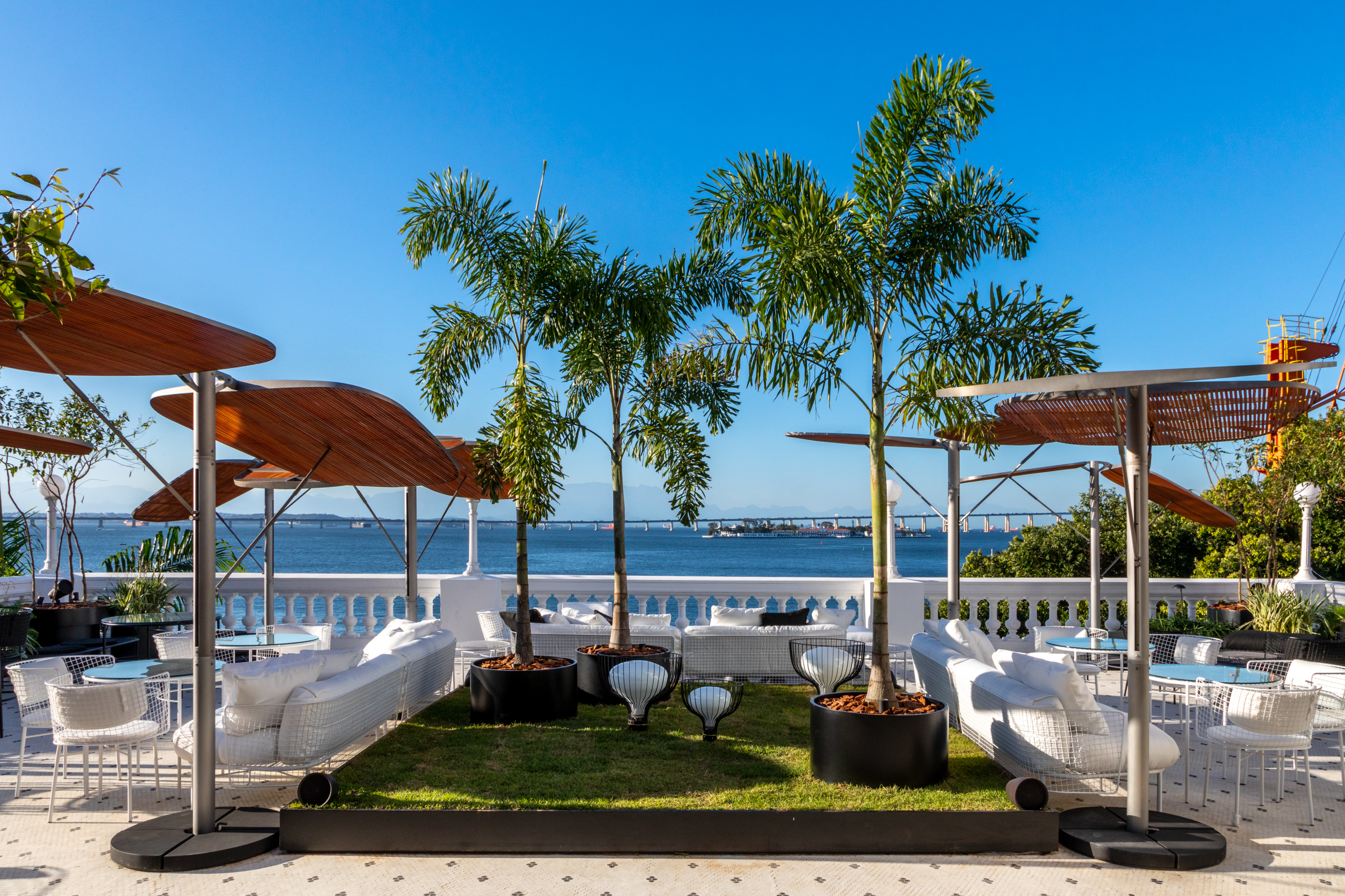 Gisele Taranto Arquitetura - CH'A Bar. O universo dos chás ganhou um bar só seu. No cardápio, chás tradicionais – quentes e gelados –, drinks alcoólicos, sobremesas e até petiscos. Na decoração, paleta de cores influenciada pelos diferentes tipos da bebida. O mobiliário e as pastilhas do piso são uma referência aos chás preto e branco. O paisagismo faz alusão ao terceiro tipo de chá, o verde. E os cachepôs foram inspirados nas tradicionais peneiras usadas na seleção das folhas. A arquitetura do espaço também foi valorizada com uma intervenção de Marcelo Catalano na Torre do Relógio, que poderá ser vista de toda a Praça Mauá.