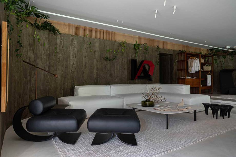 Casa 245 - Laís Galvão. O loft descomplicado da Casa 245 foi inspirado no traço simples e genial de arquitetos como Oscar Niemeyer e Lina Bo Bardi. Os ambientes integram as funções da moradia, conferindo grande praticidade às atividades do cotidiano. O grande painel de concreto e madeira une os ambientes de sala de estar e quarto, proporcionando uma sensação de continuidade visual. O espaço nos leva a um grande passeio pela arte baiana e pelo design brasileiro, com destaque para a poltrona Oscar, a cadeira Tripé e as obras de Mário Cravo Jr. e de Emanuel Araújo.