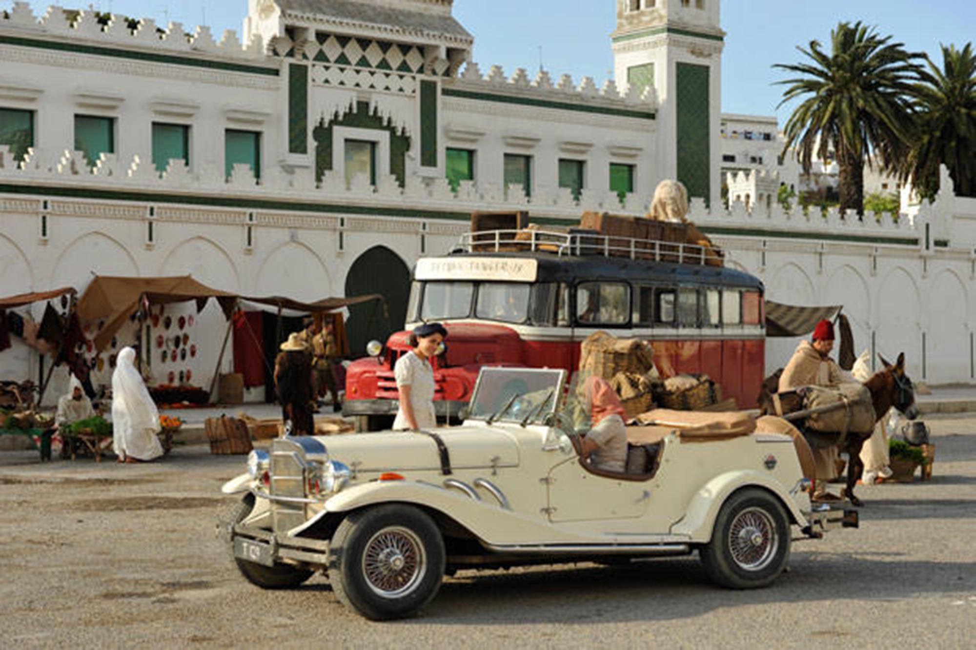 Prédio branco e carros vintage à frente