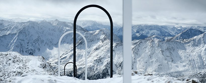 Portais em forma de arco brancos e pretos enfileirados em montanha com neve