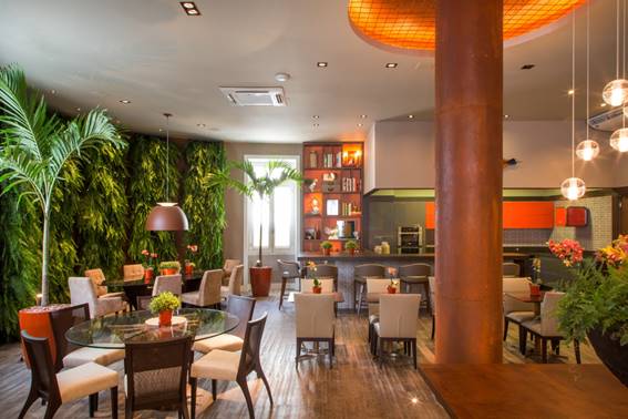 Restaurante com parede verde. Mesas e cadeiras