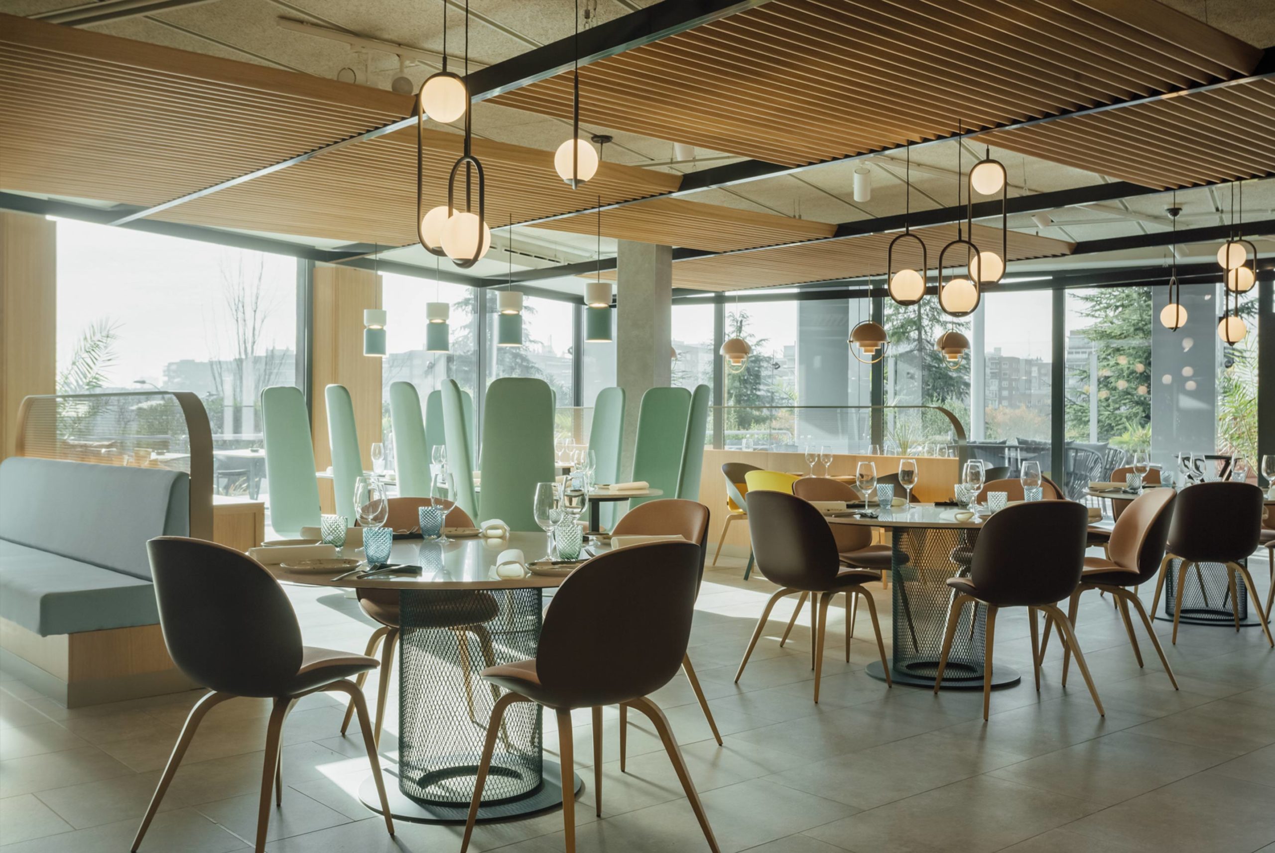 Restaurante com mesas circulares e luminárias esféricas