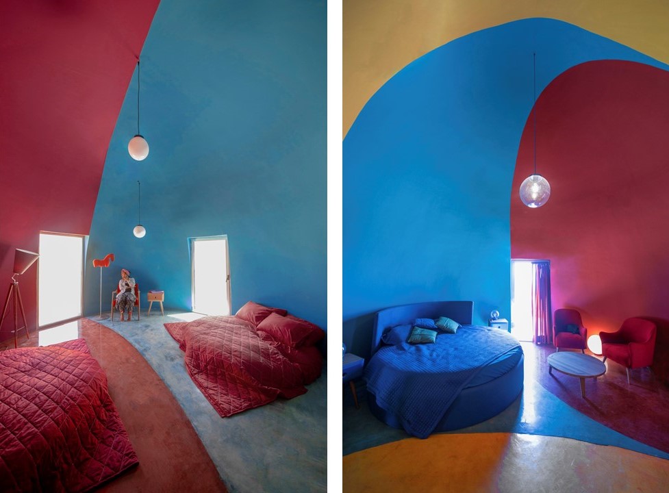Interior da casa. Paredes coloridas de azul e soa, camas também coloridas