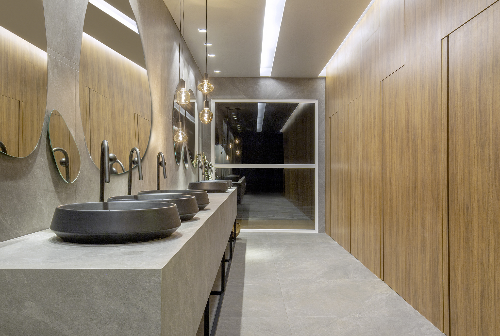 Matheus Alves - Lavabo Sensações. O espaço de 48 m² celebra a tecnologia e a simplicidade. No ambiente é possível observar a evolução no emprego de materiais como porcelanato, que ganha diferentes formatos, padrões, texturas e cores. Louças e metais conferem um design simples e icônico, onde têm como função o valor simbólico de consciência no uso de recursos naturais. “O projeto aposta em texturas que estimulam o tato, contraste de cores e matérias que resgatam memórias afetivas ou criam novas.”, observa o profissional estreante na mostra.