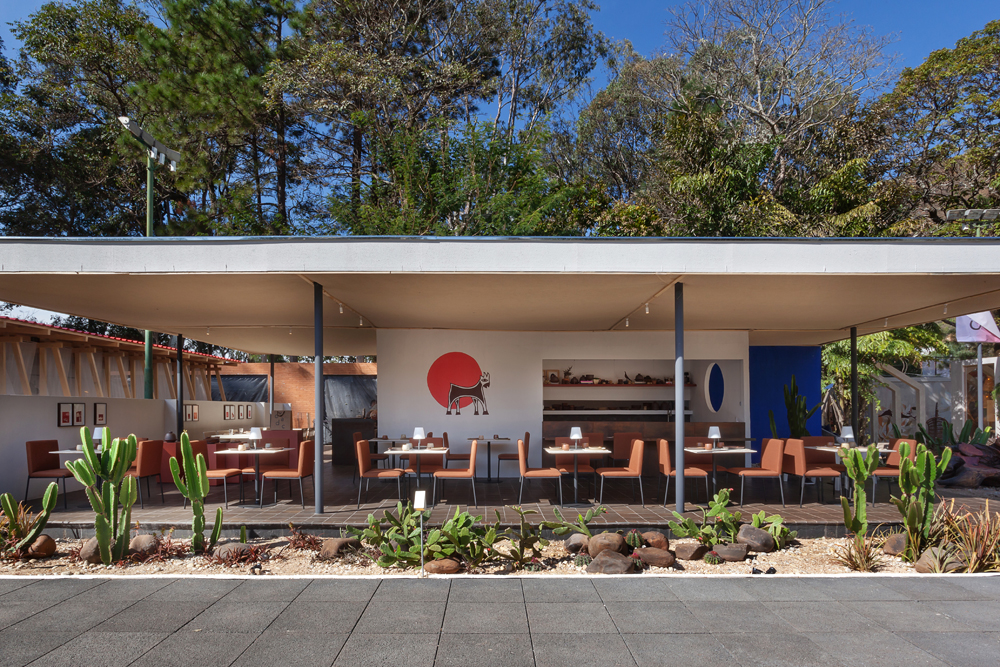 Sarah James - Restaurante "O chef e o cabra". Os tons terrosos já anunciam: o ambiente traz uma pitada do Nordeste como inspiração. As cores lavadas permitem que o colorido da comida seja o protagonista. Do aço cortem no bar, balcão e parede lateral, à proposta de um jardim com jeito de caatinga e clima de mata atlântica. Despretensioso e cheio de charmes, o projeto é norteado pela gastronomia e pela estética armorial.