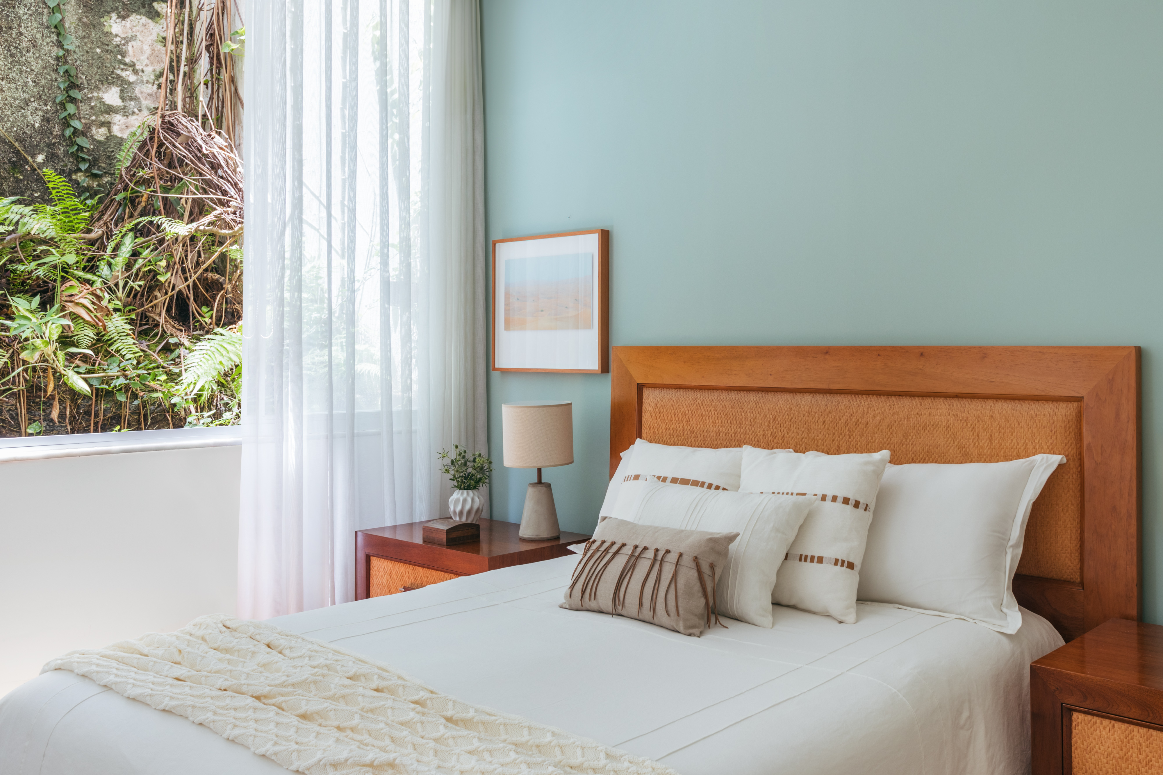A natureza carioca circunda todo este apartamento de 245 m². Projeto de Vivian Reimers. Na foto, quarto com parede verde, cama e quadro.