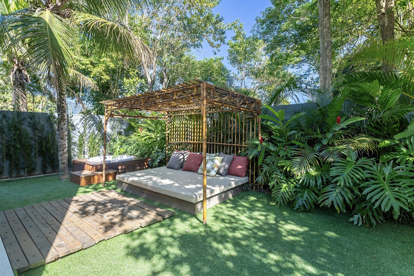 Lívia Quintella assina casa com pergolado de bambu e área com futons. Na foto, jardim com pergolado de bambu e futons.