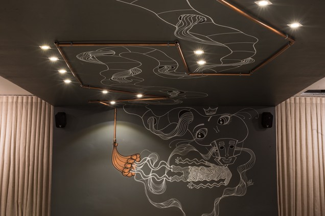 Restaurante - Gabriely Fagotti e Ulisses Calhao Filho. Vários detalhes surpreendem, como as tubulações aparentes que desenham o teto e as paredes, enquanto acompanham as intervenções artísticas.