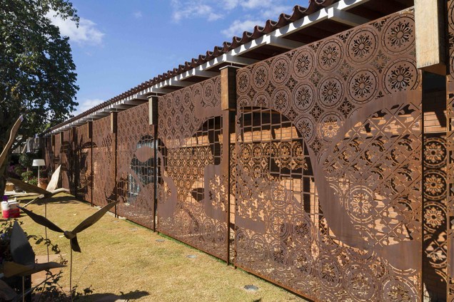 Fachada e Jardim de Saída - Paulo Pontes. O painel em aço corten, de 30m x 3m, tem concepção do artista Léo Arruda. A intervenção delicada não esconde a fachada original da casa, de 1969.