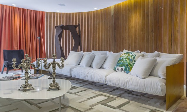 Living Borsoi – Renato Teles. Os brises em madeira são outro item original preservado, valorizado pelo generoso sofá que ocupa toda a extensão do ambiente.