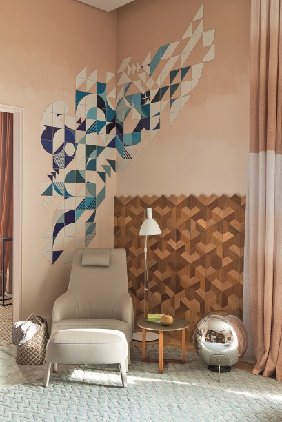 Para a Sala Íntima, Paula Neder levou a obra do coletivo Muda, que traz motivos geométricos e compõe com o revestimento que vai até metade da parede, e que também apresenta a tendência