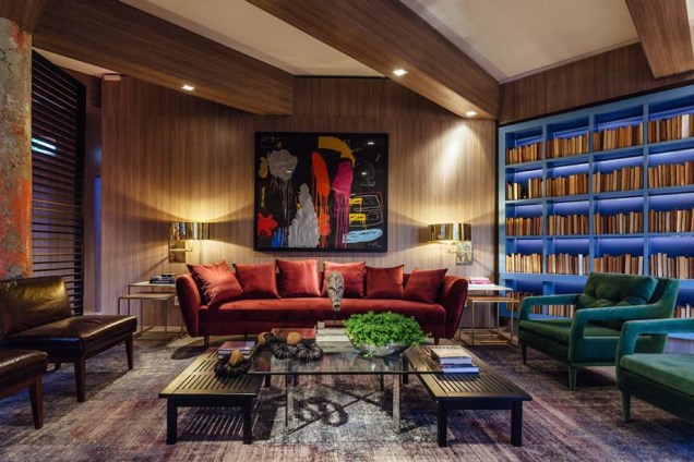 Superloft - Luiz Sentinger: ao lado da estante azul, o sofá vermelho preenche aqui a paleta de cores vibrantes, num espaço colorido sim, mas muito equilibrado e repleto de sofisticação.