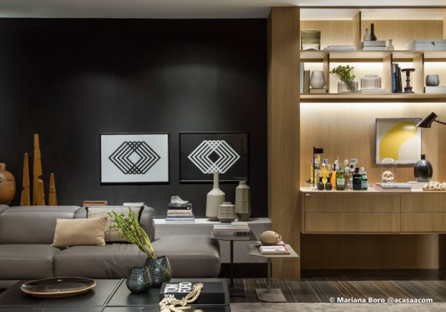 Em forma de quadros acima do sofá, estão os geometrismos da Casa Carbono, assinada por Pedro Tessarollo e Jairo Lopes. As linhas e o contraste entre o preto e o branco dão um toque especial à parede preta do espaço.