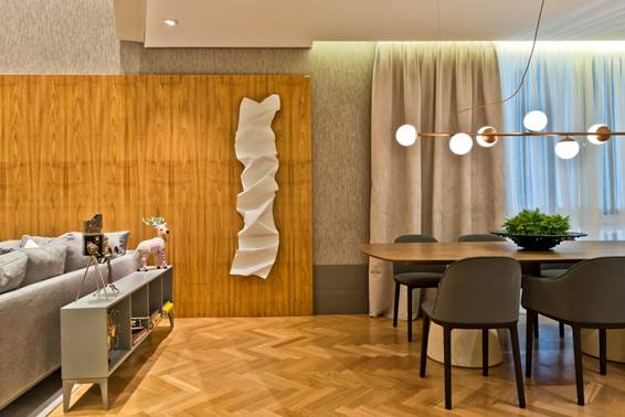 Modern House Karsten - Mariana Paula Souza. O ambiente de 115 m² possui presença marcante de madeira natural. O material aparece tanto no piso tanto nos charmosos painéis de parede que complementam a decoração.