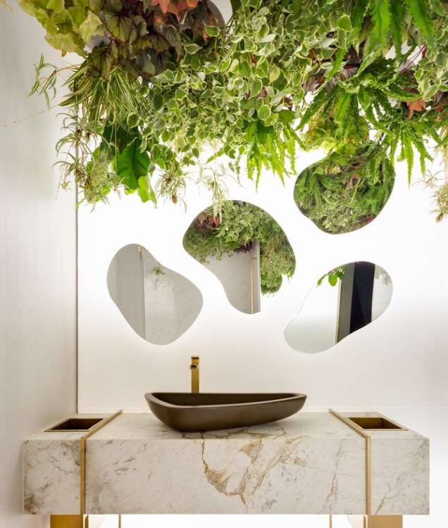 No Toilette Masculino, as profissionais Camila Rocha e Monica Pajewski optaram por espelhos em forma de bolhas para intensificar a leveza do mármore branco. Iluminados por trás, eles complementam a atmosfera cândida do jardim vertical.