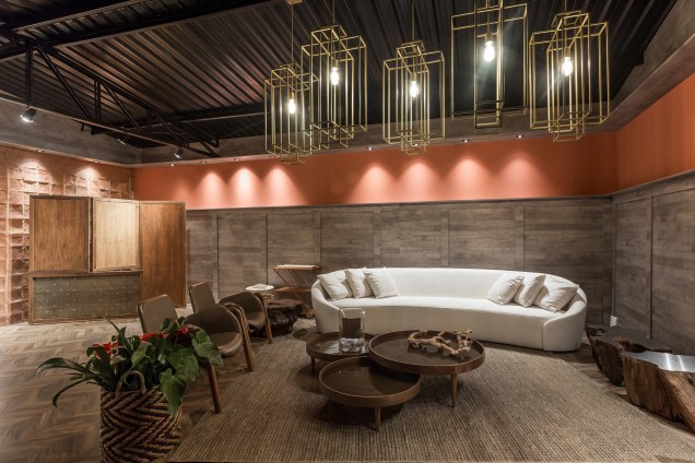 Lounge Brasilidade - Vania Toledo Martins. No lounge, a cultura brasileira é o foco, porém a profissional acrescentou alguns móveis em estilo art déco como contraste. Destaque para as luminárias geométricas douradas.