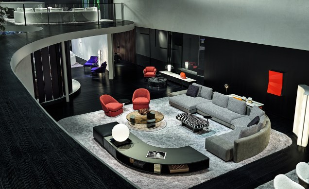 Além de confortáveis e espaçosos, os sofás também ajudam a dar forma à sala, criando um movimento que delimita a área de convivência. A mesa lateral também segue a mesma curvatura do sofá, assim estabelecendo uma dinâmica configuração em 'U'.