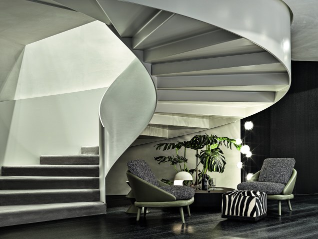 As duas escadas em espiral, uma em cada extremidade do espaço, enriquecem o ambiente como um elemento arquitetônico arrebatador, que também seguem o padrão redondo da exposição.