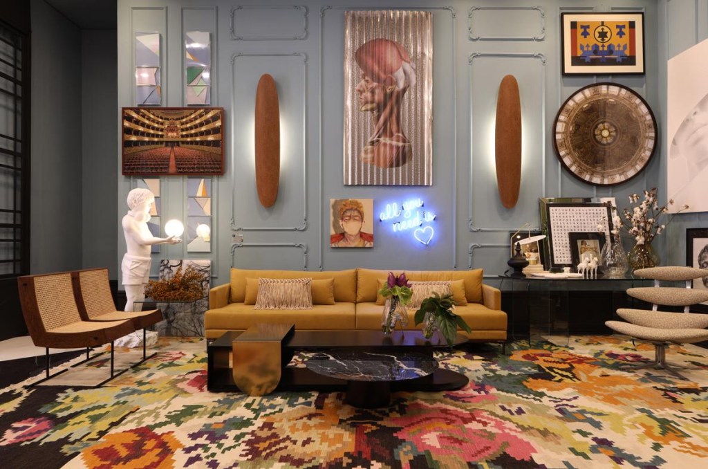 O mobiliário cria uma sala de estar eclética, com peças de antiquário, elementos que recuperam o glamour dos anos 1940 e itens atuais, como o sofá Laos revestido em veludo amarelo.