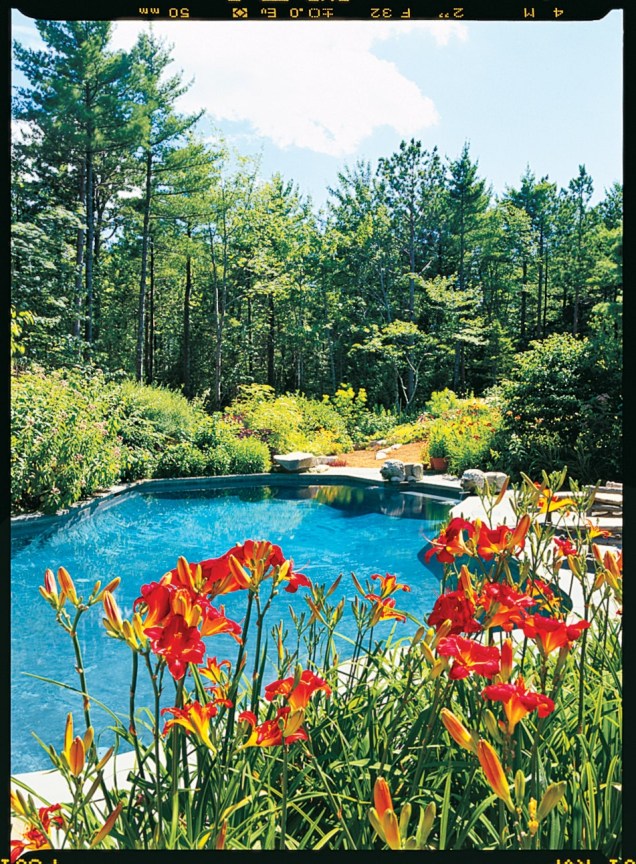 Este extenso complexo do Maine na ilha de Mount Desert é chamado de Rockridge. A piscina da propriedade, rodeada por flores, foi projetada para se parecer com a forma orgânica de um lago. Perto dali, o deck protegido de uma casa com piscina contém cadeiras e sofás de vime para se sentar enquanto aprecia a vista.