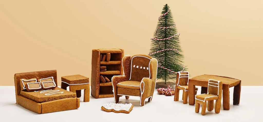 Cama, poltrona, mesa e cadeiras feitas de biscoito. Árvore de Natal ao fundo