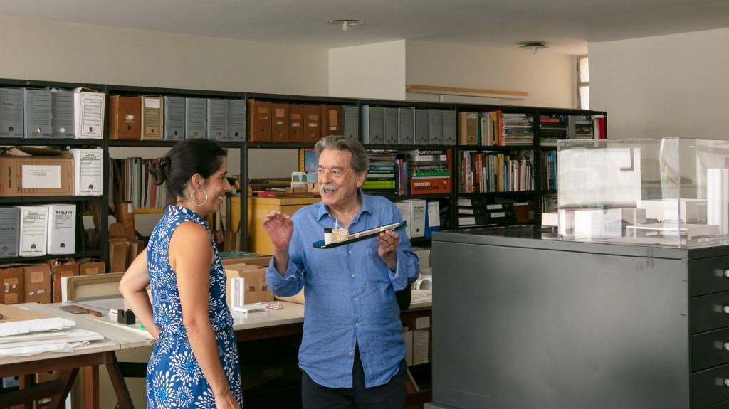 Arquiteto Paulo Mendes da Rocha em seu escritório segurando uma maquete
