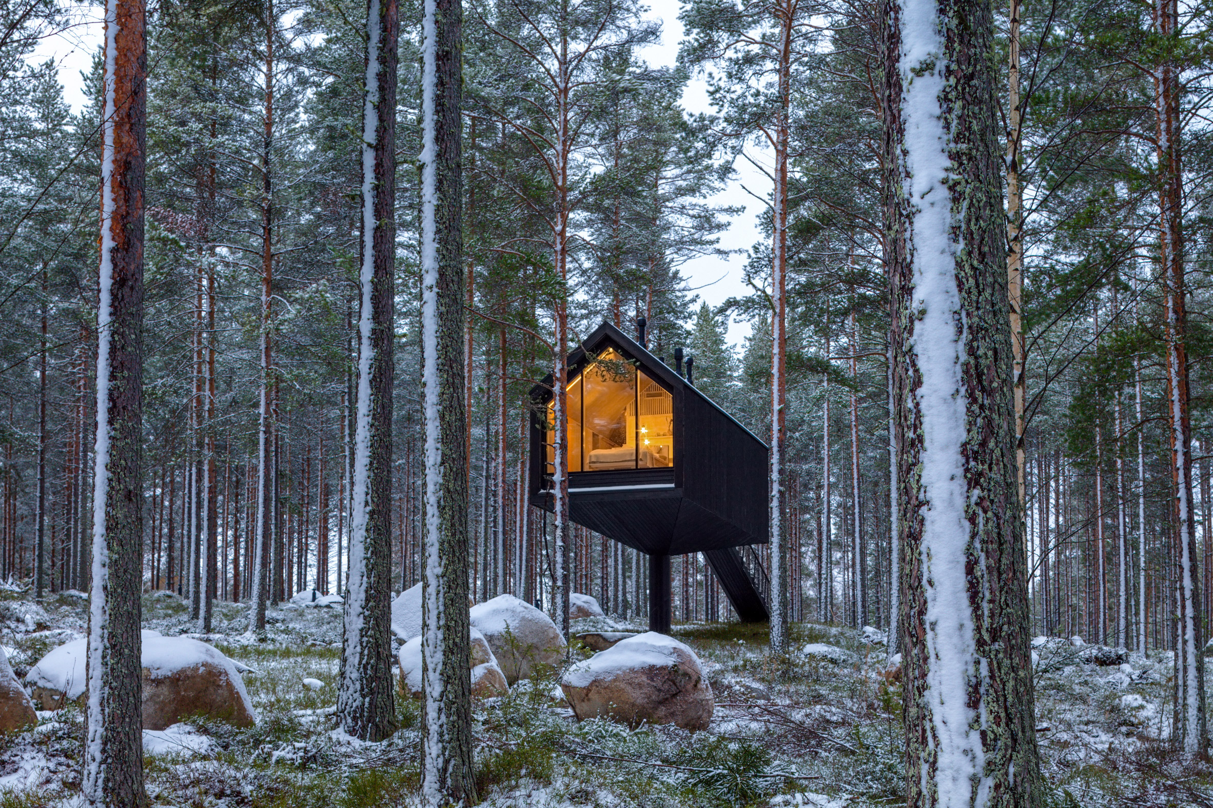 Cabana de cor preta assinada pelo Studio Puisto que elevou-a em uma única coluna. Localizado no Parque Nacional Salamajärvi, na Finlândia.