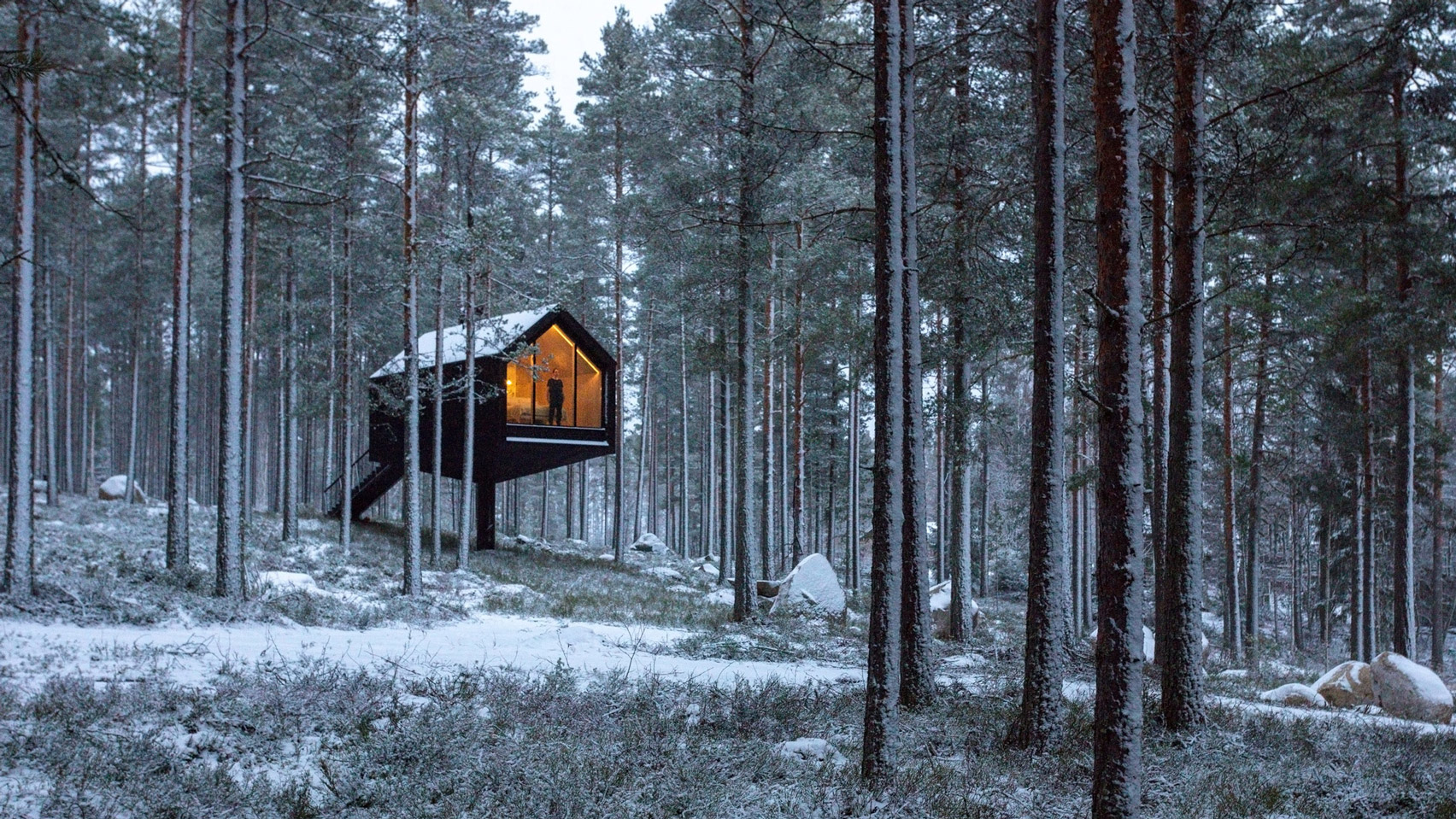 Cabana de cor preta assinada pelo Studio Puisto que elevou-a em uma única coluna. Localizado no Parque Nacional Salamajärvi, na Finlândia.