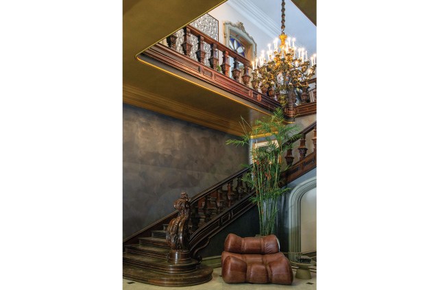 Ao pé da escada esculpida em jacarandá, está posicionado o sofá Fardos, do Atelier Ricardo Fasanello, criando um lounge particular à parte da composição.