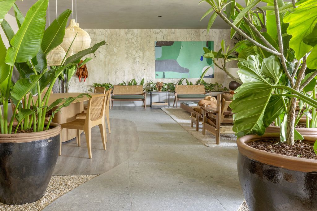Lounge Garden, projeto de Pedro Ernesto e Leandra Castro para a CASACOR Goiás 2021. Na foto, sala de jantar e jantare, com móveis de madeira, vasos de plantas e quadros.