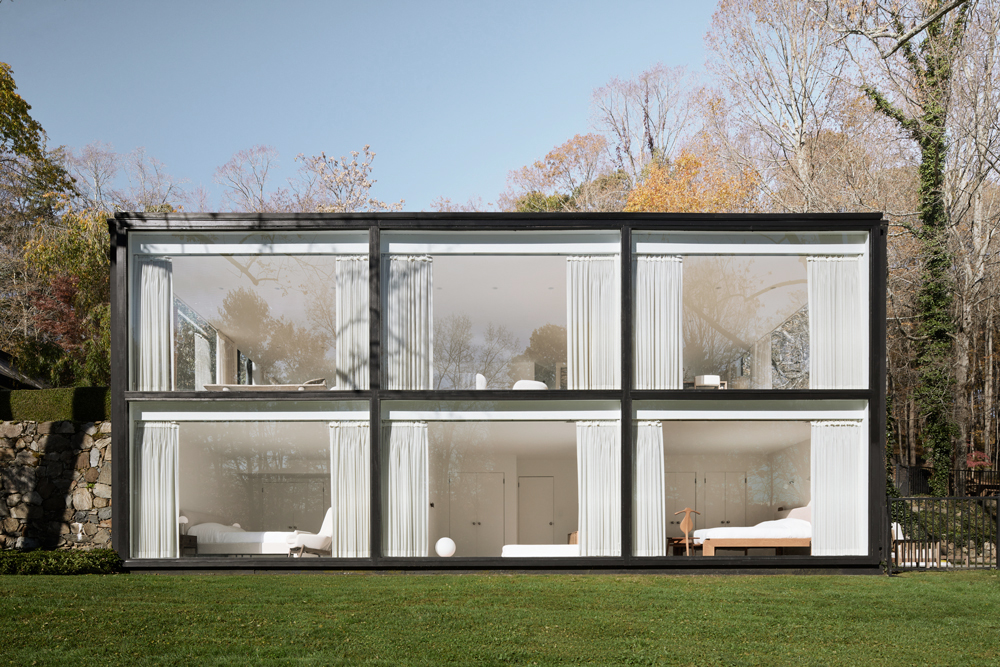 Décor eclético e minimalista ganha protagonismo nesta casa rodeada de vidro