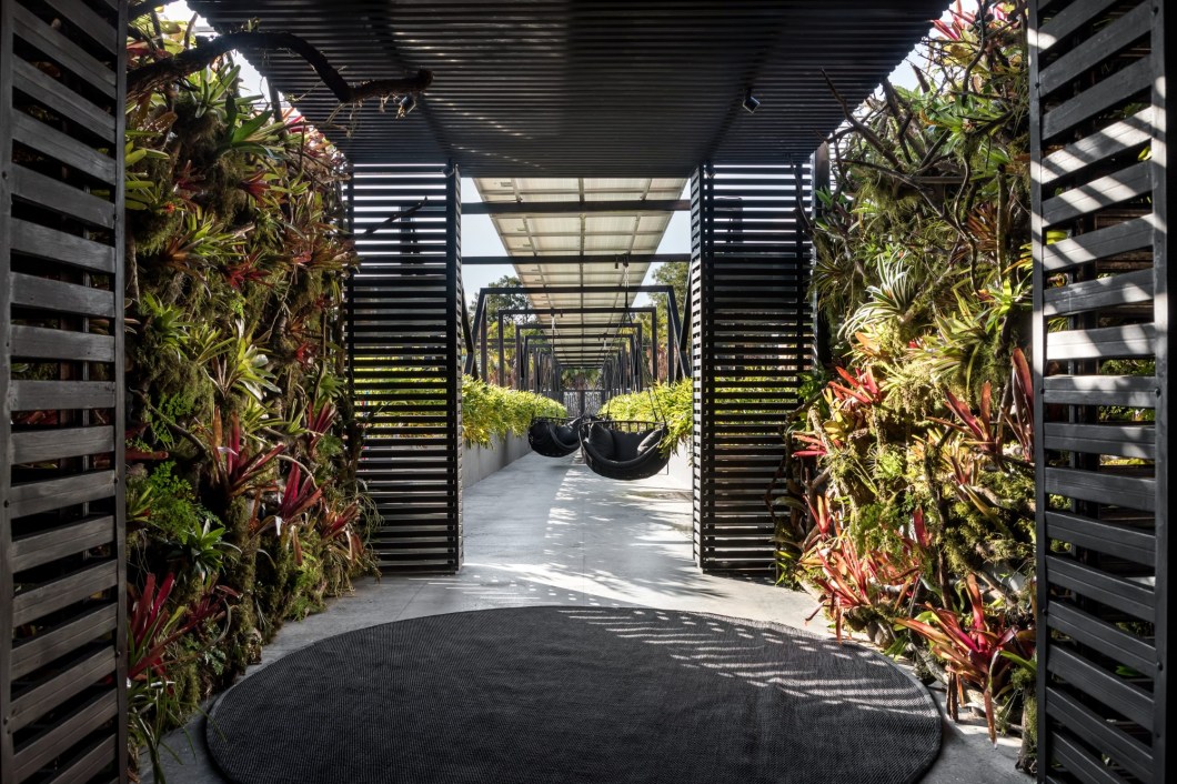 Wolfgang Schlogel - Sunset Boulevard. A ideia do projeto foi transformar a passarela de entrada do evento em um passeio envolvido por vegetações, som e aromas da natureza. Propomos balanços para, confortavelmente observarmos o indescritível pôr-do-sol.