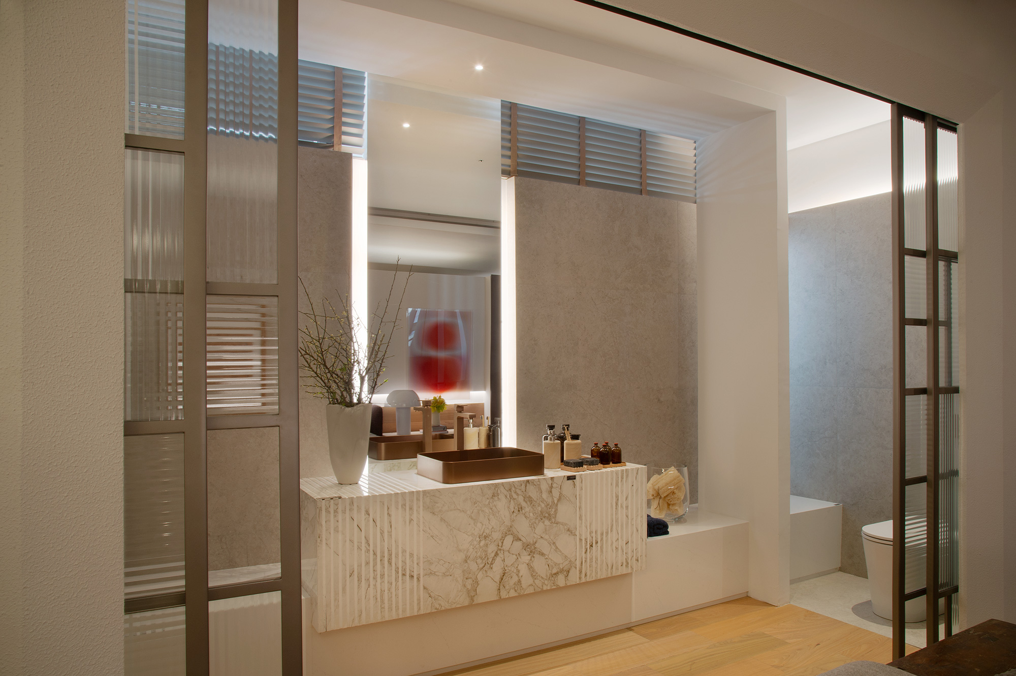 No banheiro, um banco produzido com Silestone® Et. Statuario compõe com a bancada feita de marmorizado Dekton® Bergen.