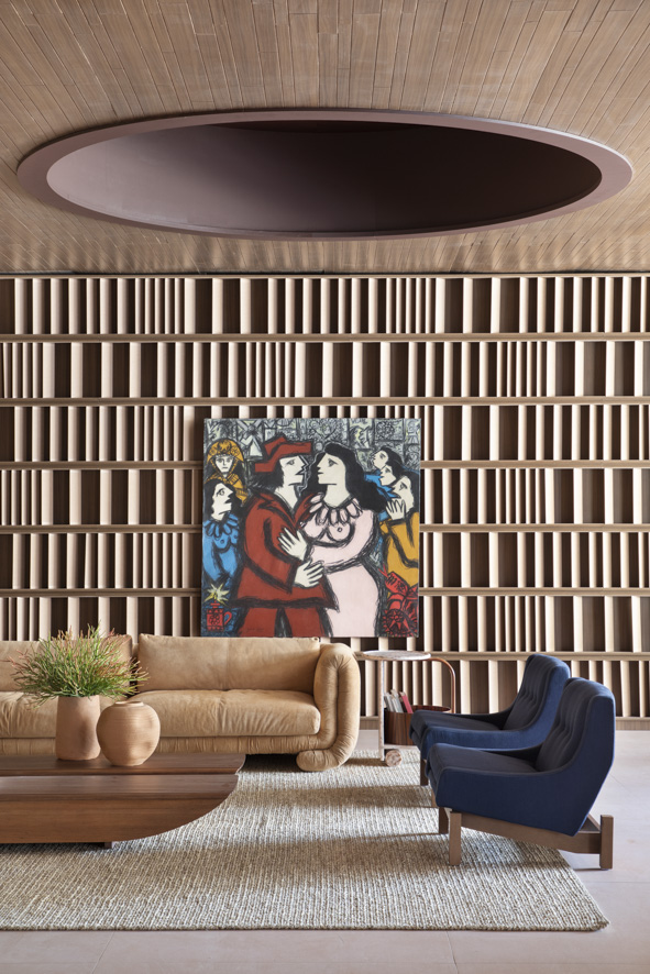 Sala com brises de cerâmica; sofá curvo; pintura