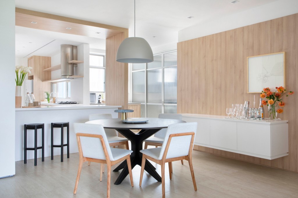 Apartamento de 126 m² possui vista para o Pão de Açúcar. Projeto de João Panaggio. Sala de estar, cozinha a painel de marcenaria.