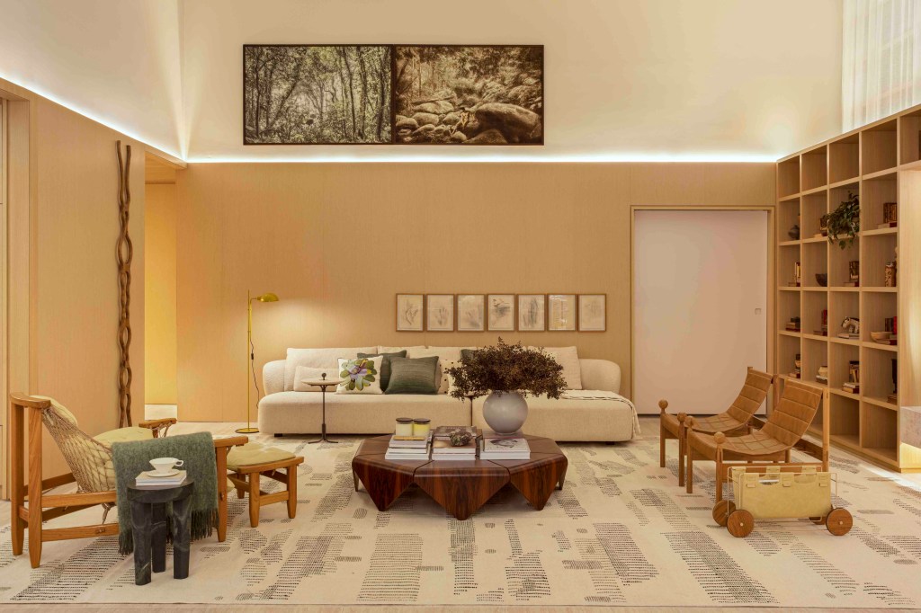 Da Hora Arquitetura - Loft Vastu. Projeto da CASACOR São Paulo 2023. NA foto, sala de estar com pé-direito alto, quadro, tapete, sofá e poltrona.